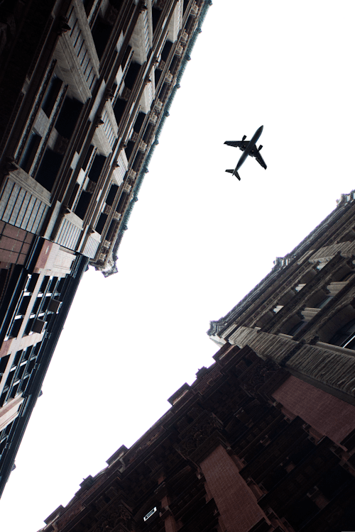 Airplane Flying Over the Buildings