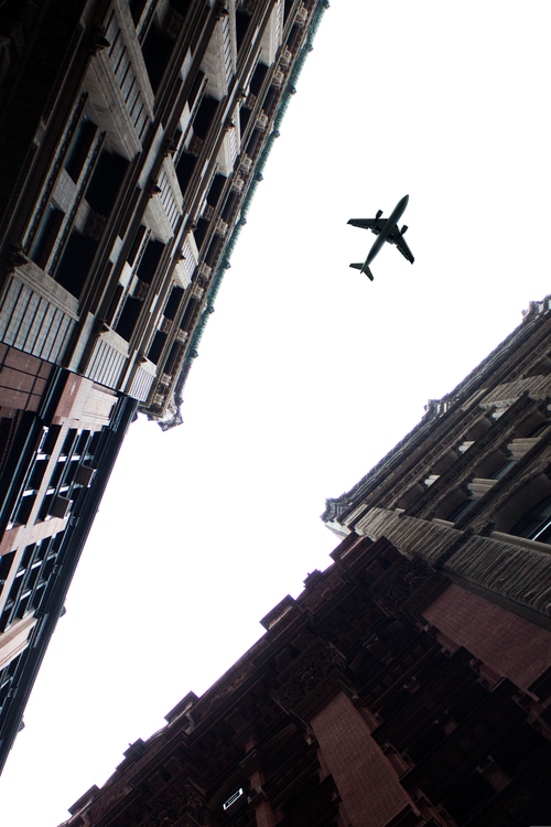 Free Silhouette of an airplane soaring over skyscrapers in New York City, USA. Stock Photo