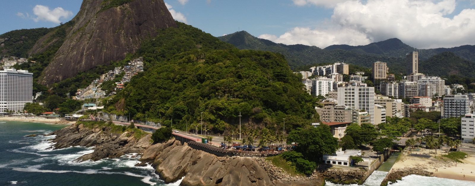Stunning aerial view of Vidigal Beach with lush greenery and cityscape in Rio de Janeiro, Brazil.