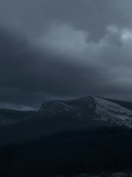 Moody mountain landscape with dark clouds, perfect for dramatic visuals.