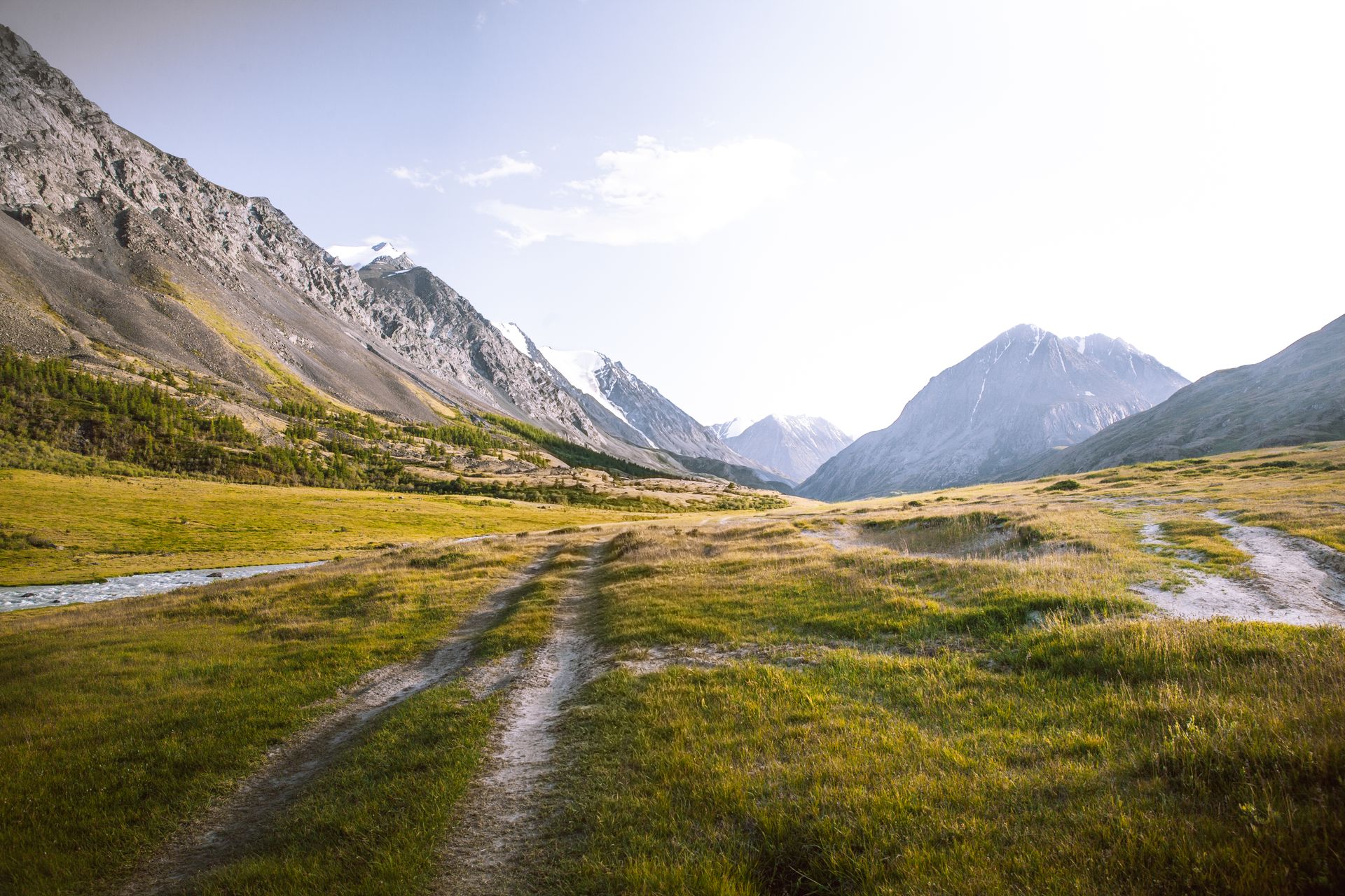 Road next to River in Valley between Mountains