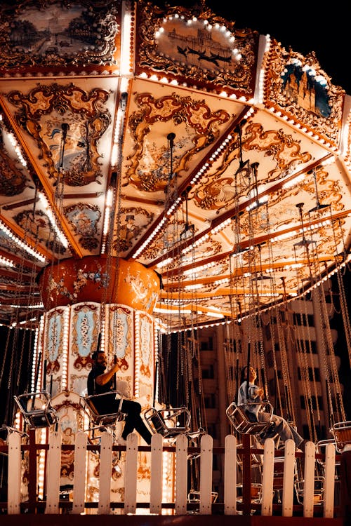 People Riding a Swing Ride in Amusement Park
