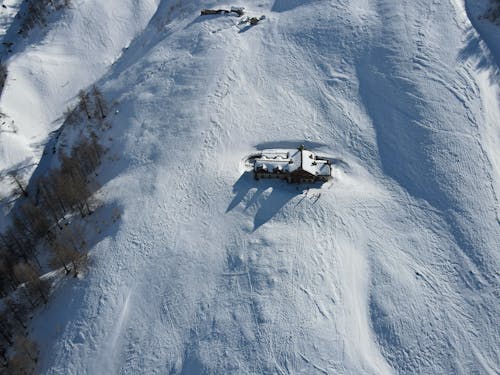 Aerial Shot of a House on Snow Covered Ground 