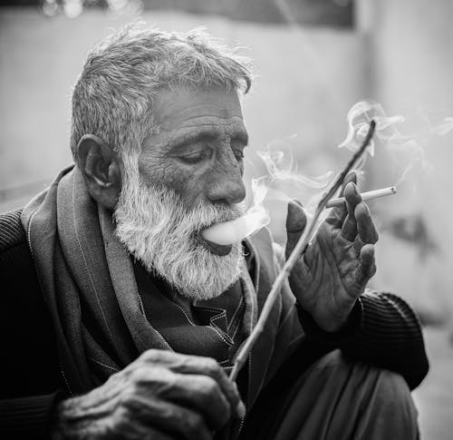 Monochrome Shot of an Elderly Man Smoking a Cigarette