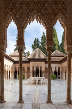 Exquisite view of the Alhambra's ornate courtyard showcasing intricate Islamic architectural details.