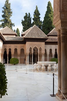 Elegant courtyard view of Alhambra Palace showcasing Islamic architecture and serene atmosphere.