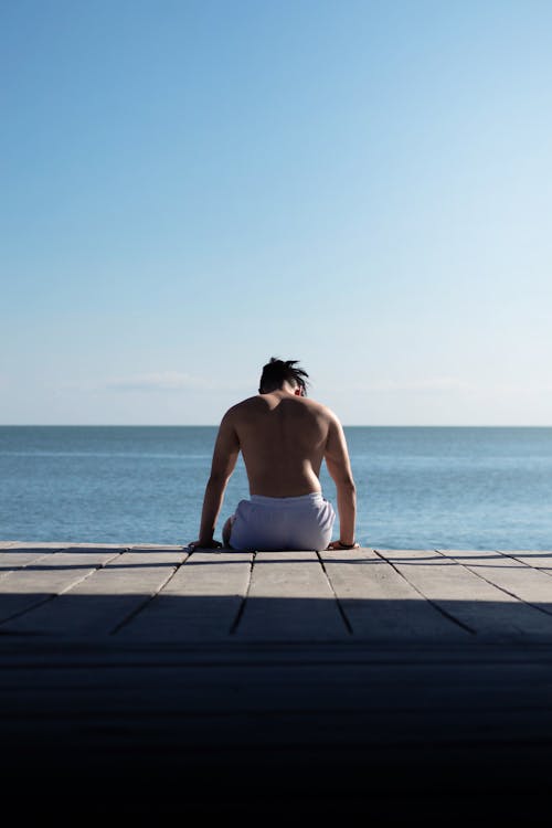 Back View of a Shirtless Man Sitting