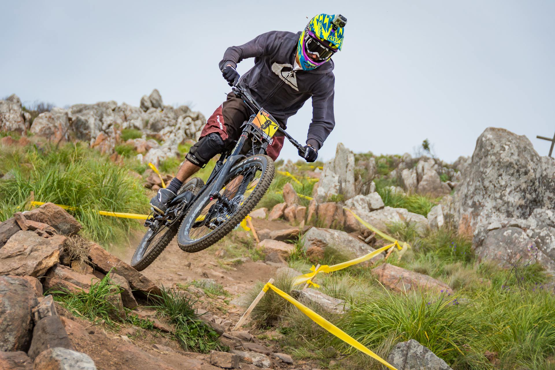 A cyclist navigates a rocky downhill trail, showcasing extreme mountain biking skills.