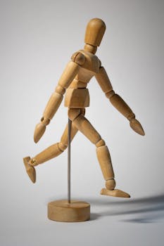 A wooden art mannequin posed in a walking position, perfect for design and creativity concepts.