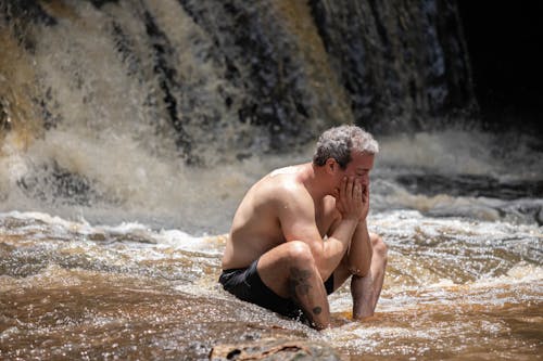 Shirtless Man Sitting on Water