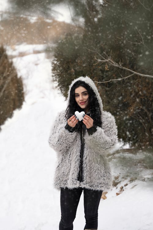 Woman in a Fur Coat Holding a Heart Shaped Snow