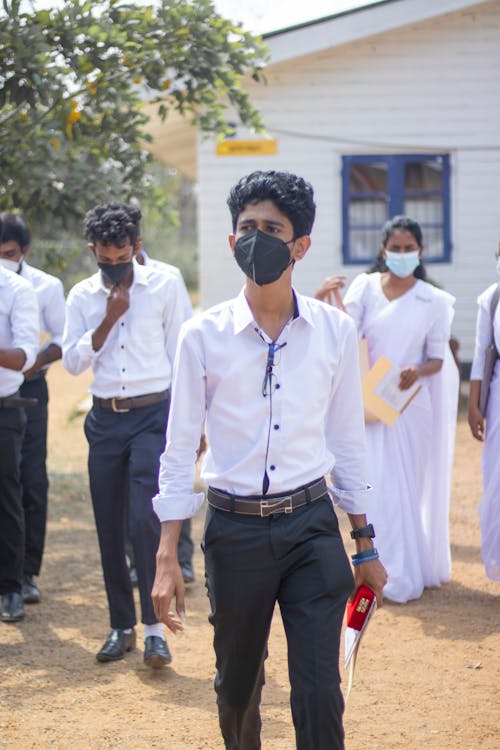 Free Teenage Boy in White Long Sleeve Shirt Wearing a Face Mask Stock Photo