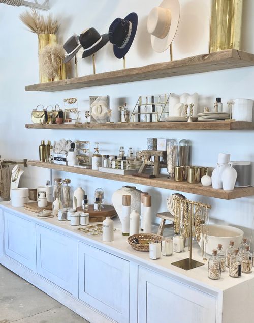 Free A stylish display of hats, kitchenware, and tableware on wooden shelves in a modern setting. Stock Photo
