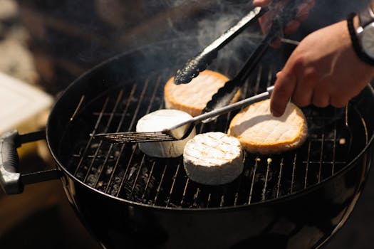 Close-up of cheese grilling on a barbecue with tongs in use, creating a smoky flavor.