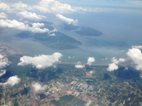 Stunning aerial shot capturing islands, coastline, and clouds from above.