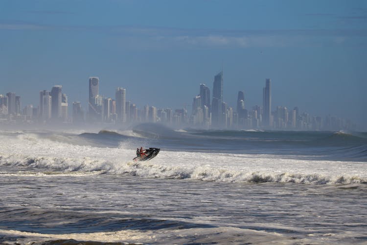 Motorboat On Wave Near City 