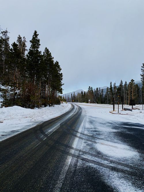Free A winding road through a snowy forest landscape, captured on a cold winter day. Stock Photo