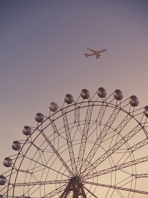 Airplane Flying Over the Ferris Wheel