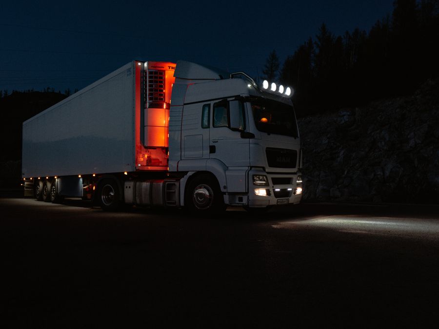 Camión con luces encendidas en la carretera de noche