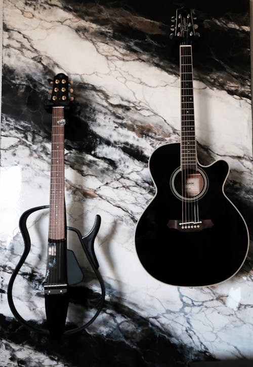 Free Close-Up Shot of Two Guitars on Marble Surface Stock Photo