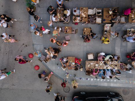 Top-down drone shot of people dining outdoors at a cafe in Novosibirsk, capturing summer vibes.