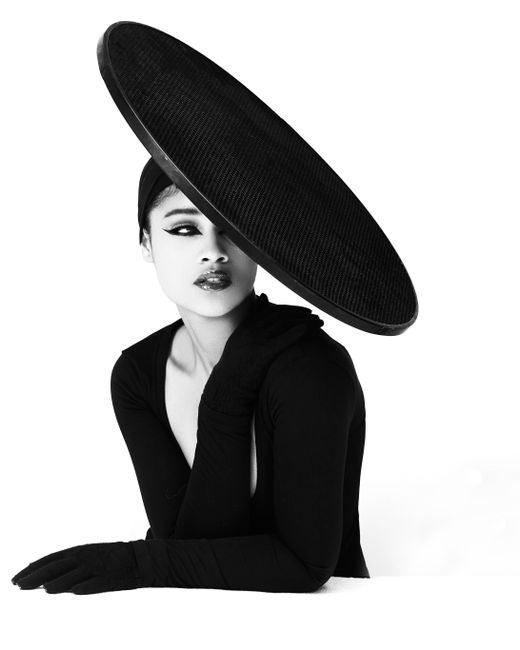 Striking black and white portrait of a woman in haute couture with a large hat.