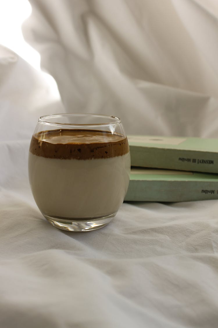 Cup Of Milk With Chocolate On White Surface