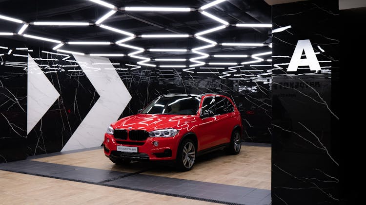 An Expensive Red BMW Car Inside The Showroom