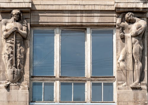 Close-Up Shot of Statues near a Window