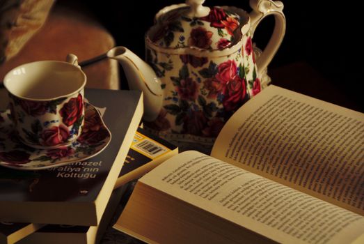 A cozy scene with floral teapot and books for an inviting reading atmosphere.