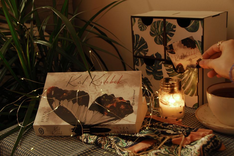 A warm evening setup featuring a book, candlelight, and decorative elements for relaxation.