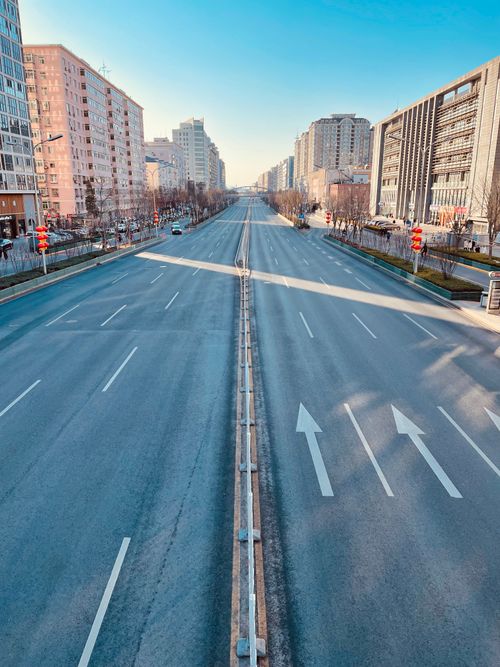 Free Aerial view of an empty urban road lined with modern buildings on a clear day. Stock Photo