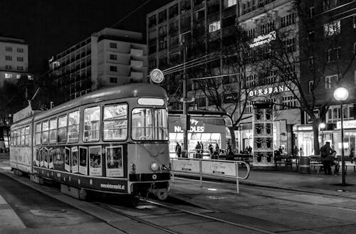 Grayscale Photography of Tram on Road in the City