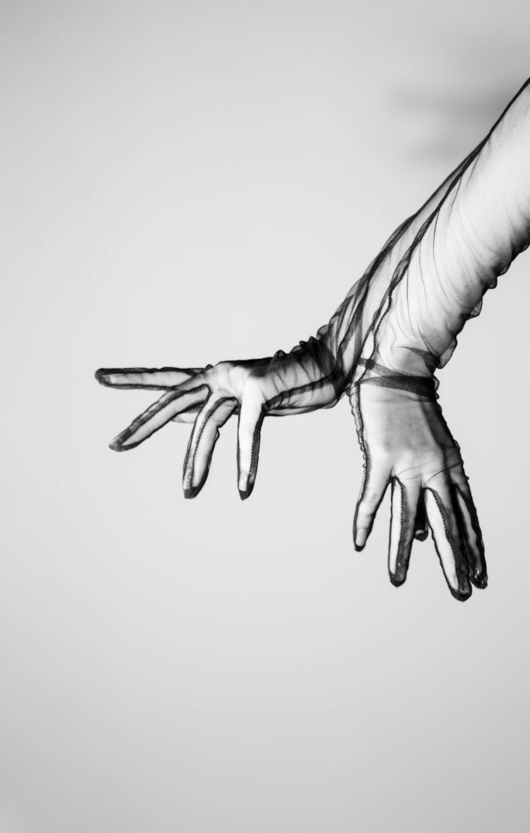 Black And White Photo Of Hands In Transparent Gloves