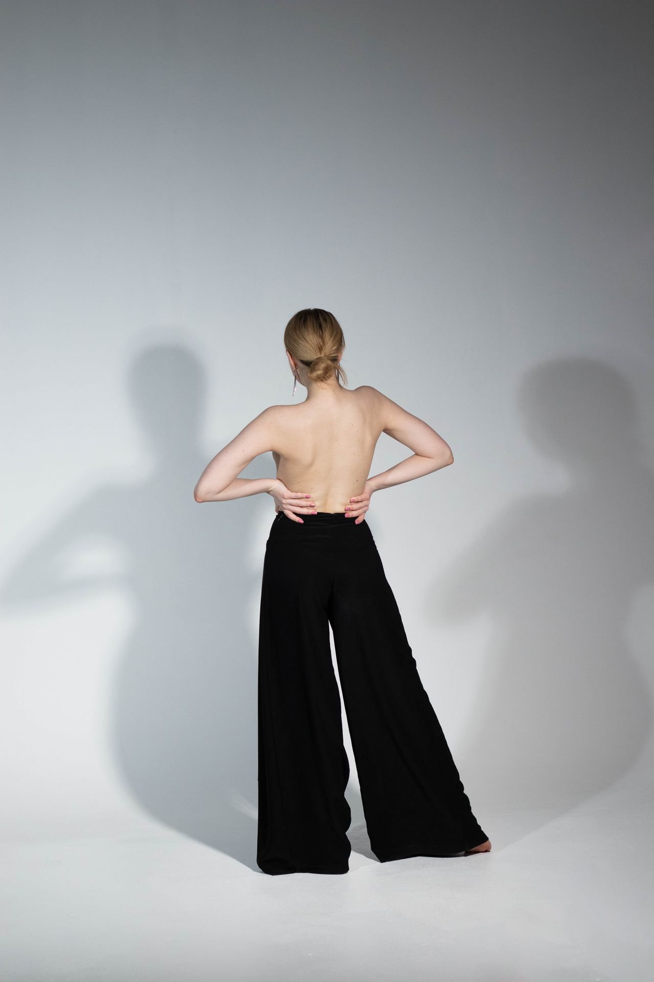 Woman from behind in black wide-leg trousers