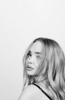 Elegantly posed black and white portrait of a young woman looking over her shoulder.