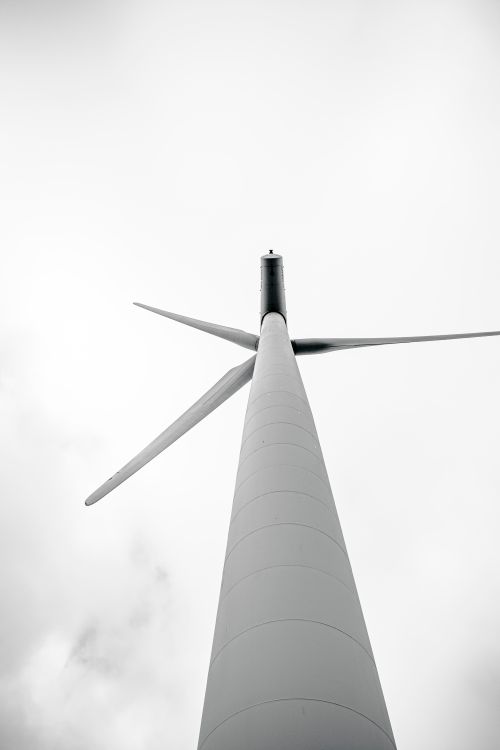 Free Low-angle shot of a wind turbine set against a cloudy sky, in monochrome tones. Stock Photo