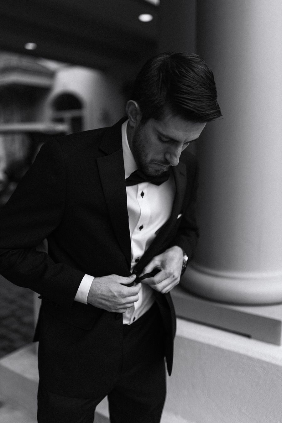 Hands fastening a jacket button, monochrome detail