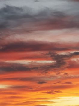 A stunning sunset sky with dramatic clouds and vibrant orange hues, perfect for nature and travel themes.