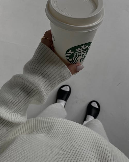 Close-Up Shot of a Person Holding a White Starbucks Coffee