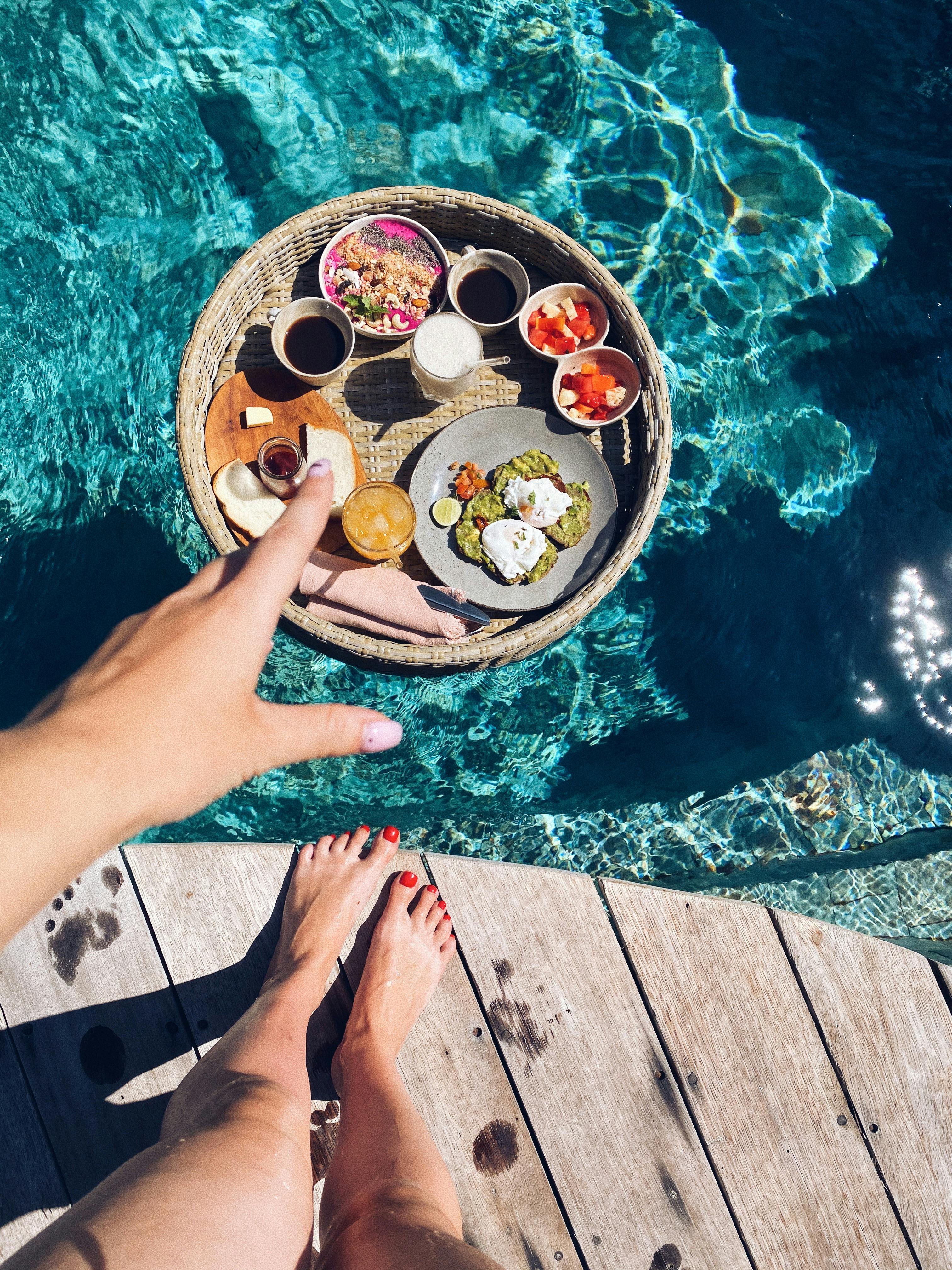Floating breakfast tray with tropical fruit and coffee on a private pool at a luxury resort in Bali for couples