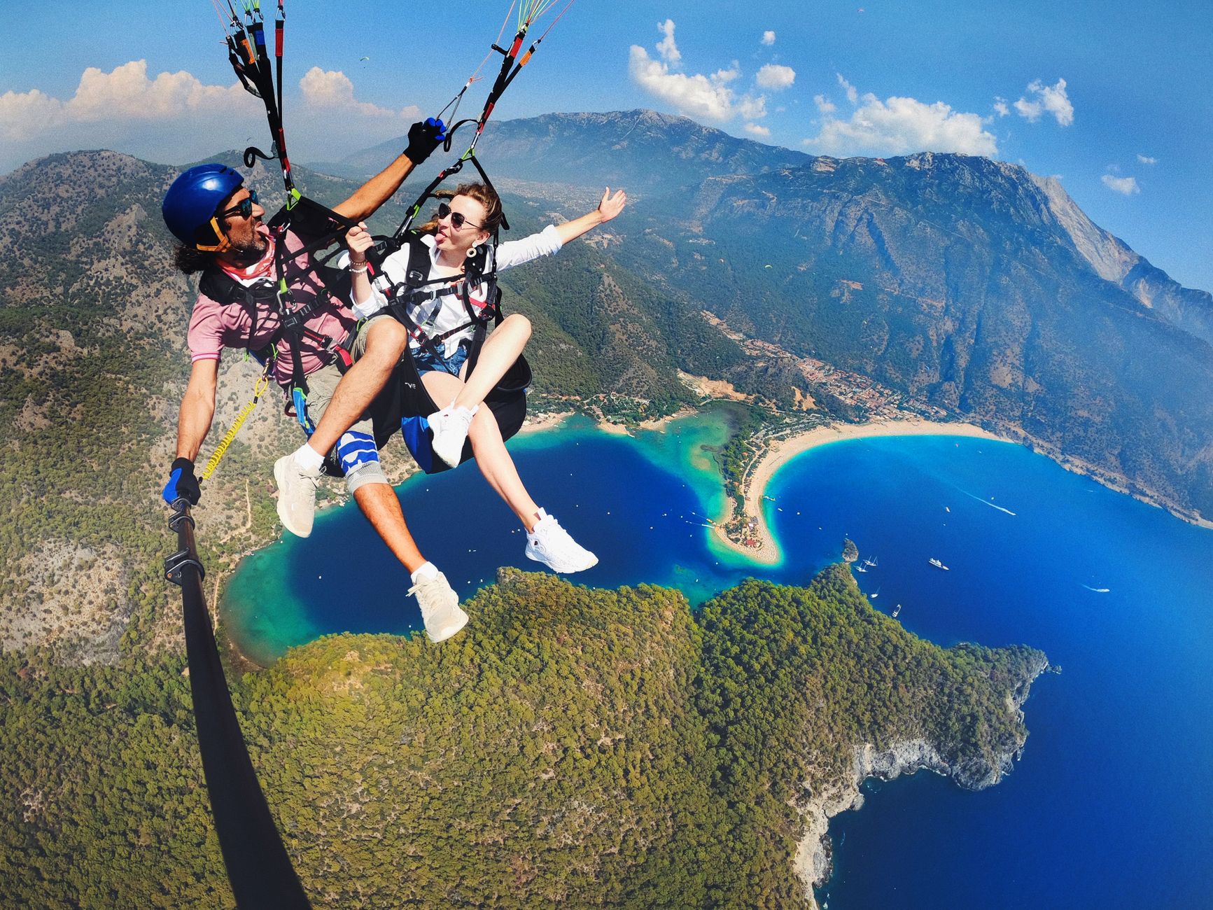 Adventure seekers enjoy paragliding over the stunning Blue Lagoon in Ölüdeniz, Turkey.