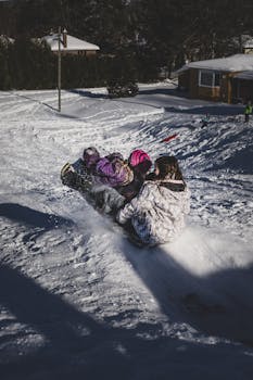 Group of children enjoying sledding outdoors on a bright winter day.