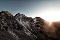 温暖的阳光照亮了崎岖、白雪皑皑的山峰，日出的景象令人惊叹