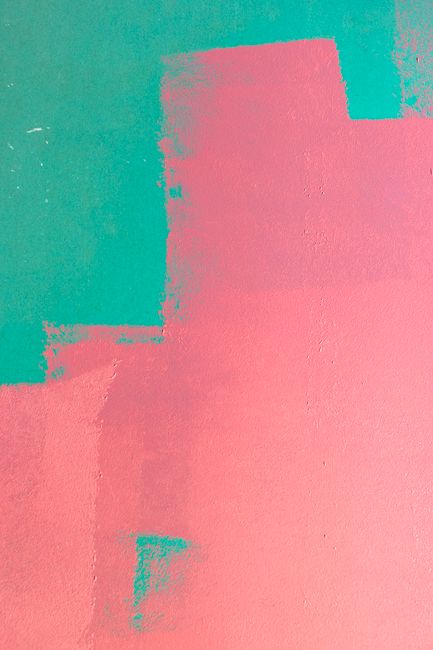 A vibrant abstract wall featuring pink and green paint textures, perfect for backgrounds.