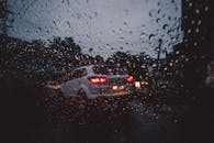 在印度帕拉卡德，透过雨水覆盖的窗户，拍摄到了夜间交通的喜怒无常街景