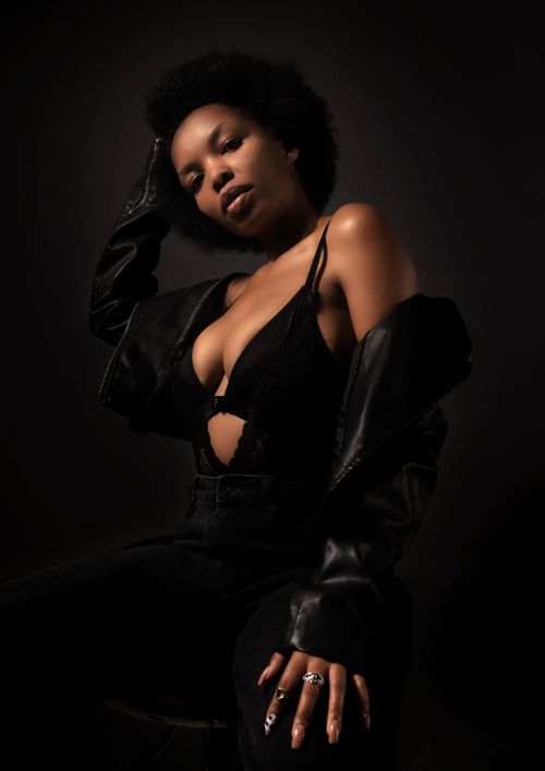 Free Elegant portrait of a woman in a black leather jacket in a studio setting. Stock Photo