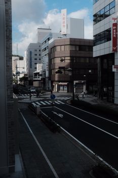 A serene city street with modern architecture and few pedestrians in daylight.