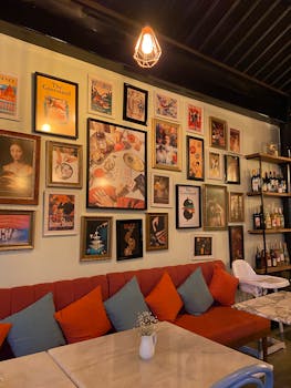 Stylish café interior featuring a vibrant wall of artwork and cozy seating.