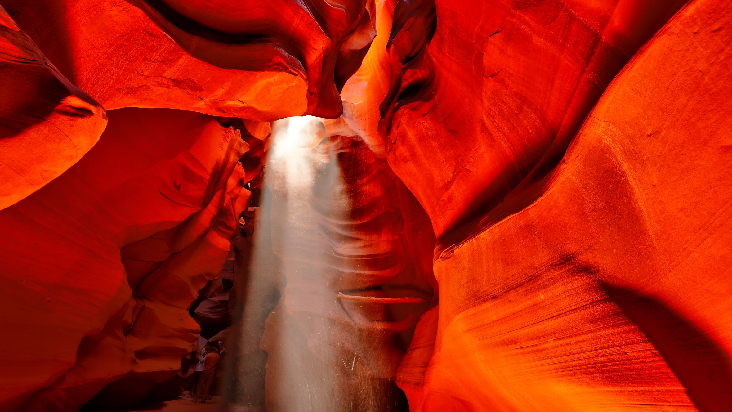 Dramatic sunlight beams illuminate the vibrant red walls of Antelope Canyon, Arizona.